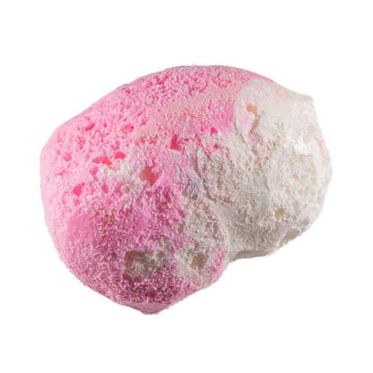 Pink and white piece of Taffy Bombs Freeze Dried Candy closeup can see texture.